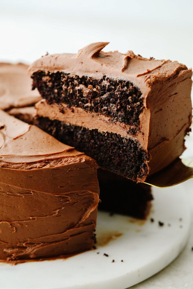 Chocolate cake is a classic, must-have recipe for every occasion! It is moist and delectable and the chocolate flavor is absolutely incredible! A slice of chocolate cake being served.