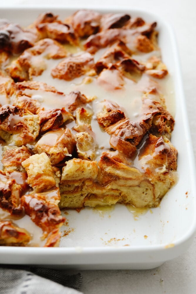 Croissant bread pudding is the perfect breakfast food! Drizzled with a creamy, vanilla sauce, this soft bread pudding is so amazing that you won't want to stop at just one piece! A pan of croissant bread pudding with a piece taken out of the pan.