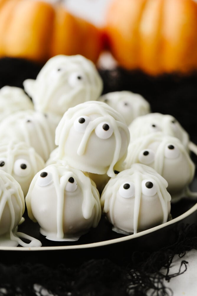 Mummy cookie bites are a ghoulish and festive treat for the Halloween season! Amazingly delicious, the white chocolate mixed with the oreo truffle is the perfect combination! A stack of mummy cookie bites.