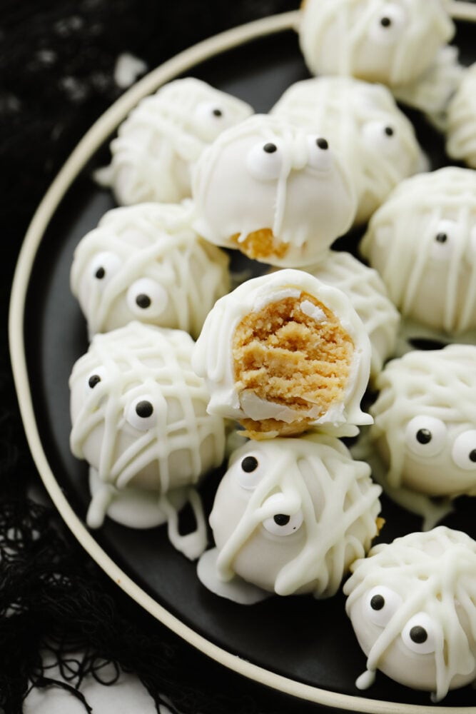 Mummy cookie bites are a ghoulish and festive treat for the Halloween season! Amazingly delicious, the white chocolate mixed with the oreo truffle is the perfect combination! A mummy cookie bite with a bite taken out of it.