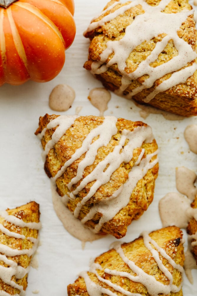 Pumpkin scones are absolutely mouthwatering and delicious! Filled with pumpkin flavor and drizzled with cinnamon icing, this is a breakfast option that you won't be able to pass up! The top view of a pumpkin scone.