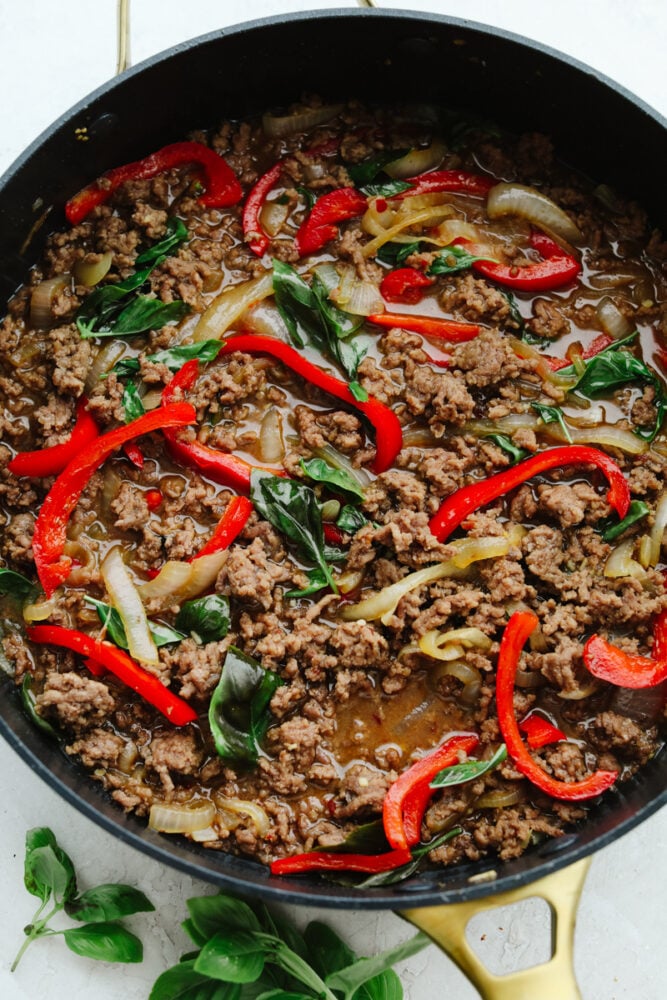 Thai basil beef is simple and delicious! It's made with a homemade Thai sauce that has a bold and brilliant flavor and can be thrown together in less than 30 minutes. It is SOO GOOD! Ingredients cooking in a pan.