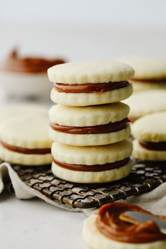 These alfajores cookies are simply divine! Their texture is perfectly soft and once you add in that creamy dulce de leche filling, well... Let's just say these cookies aren't going to last long! A stack of alfajores cookies.