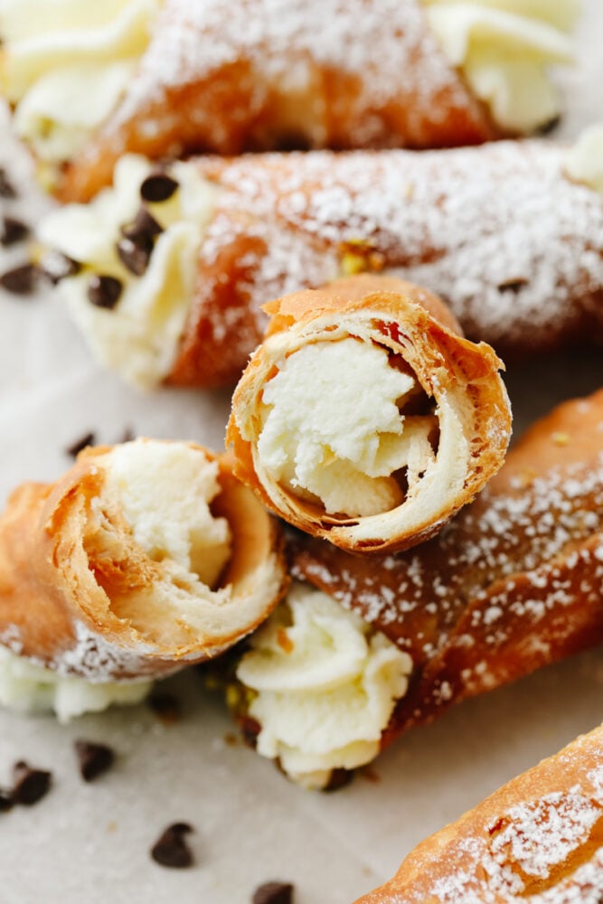Crispy and creamy, this ricotta-filled dessert is as decadent as it gets! Cannolis are the traditional Italian treats you’ll want to make again and again. Closeup of a cannoli broken in half.