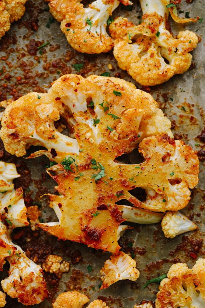 Making roasted cauliflower steaks is the best way to show all this veggie has to offer! They're amazingly tender and tossed in a mouthwatering blend of garlic, paprika, and parmesan. Closeup of a seasoned cauliflower steak.