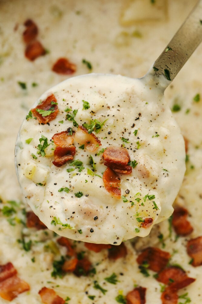 Creamy Clam Chowder with potatoes and vegetables is one of my favorite easy soup recipes! It's thick and creamy and tastes as if it came straight from a restaurant! It's SOO GOOD! A close up of clam chowder in a ladle.