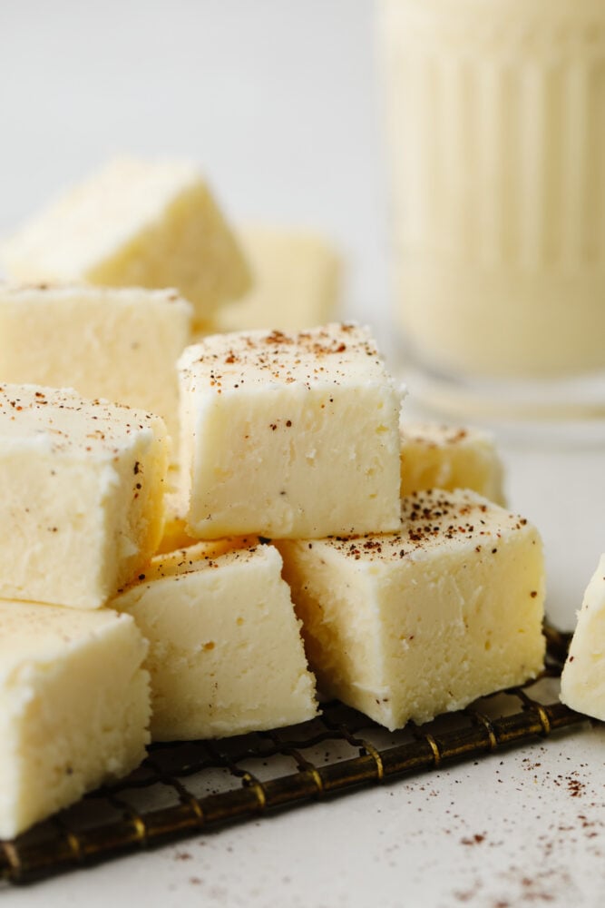 This eggnog fudge is every eggnog lover's dream! Each bite is filled with melt-in-your-mouth white chocolate and dusted with nutmeg! Cubes of eggnog fudge stacked on top of each other.