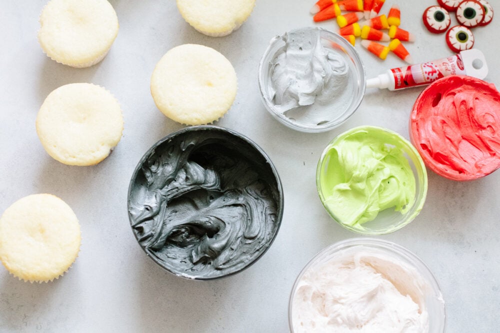 Halloween cupcakes are as tasty as they are cute! Moist vanilla cupcakes are frosted with timeless Halloween characters for an unforgettable treat! Various colors of frosting, decorations, and unfrosted cupcakes.