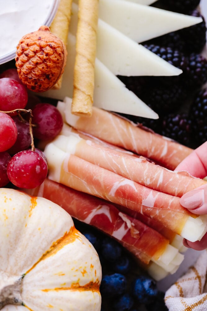 This fall charcuterie board is easy to make and is perfect for all of the parties this season! Packed with colorful and delicious food it is sure to be a hit with all of your guests! Meat on a charcuterie board.