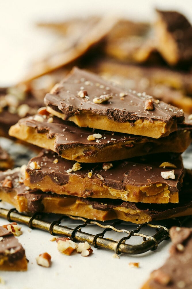 Homemade toffee is super simple with no candy thermometer required! This buttery chocolate treat is a must-make recipe this holiday season! A closeup stack of 4 pieces of toffee.