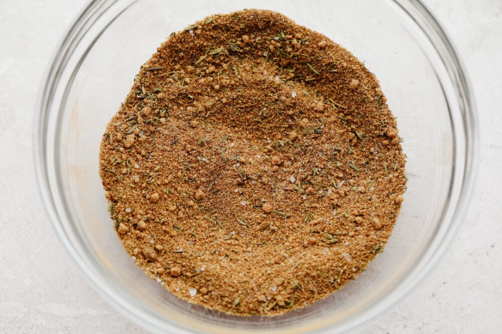 Jerk seasoning is the most deliciously sweet and savory blend of spices! It's simple to use and even more easy to make! You will have yourself a custom homemade seasoning in less than 5 minutes! Jerk seasoning all mixed up in a glass bowl.