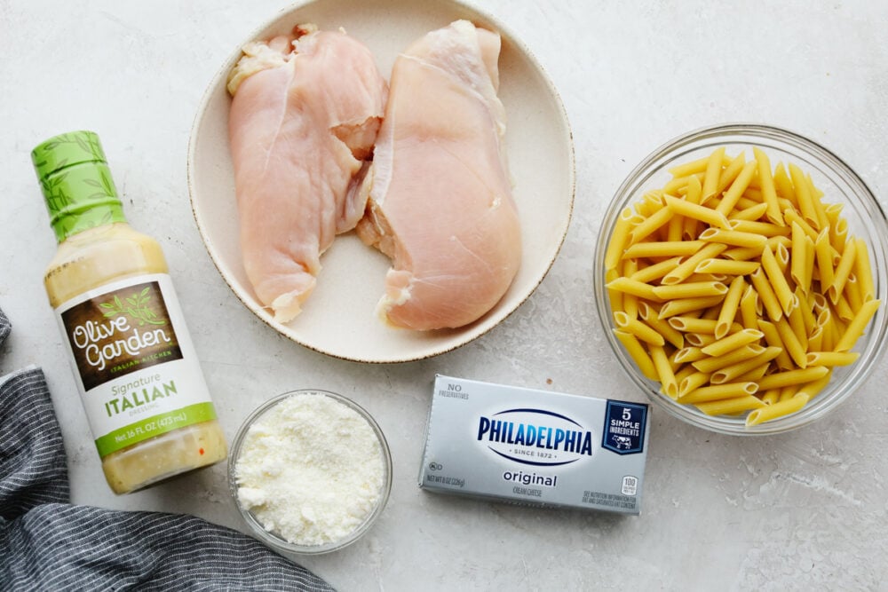This Olive Garden crockpot chicken is to die for! The juicy and tender chicken cooked with some pasta is insanely delicious! Plus, it's super easy which is a total win-win! Ingredients laid out for Olive Garden crockpot chicken.