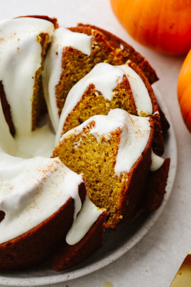This pumpkin bundt cake with homemade cream cheese frosting is what dreams are made of! It's incredibly moist and loaded with all the pumpkin spice flavor. Pumpkin bundt cake sliced up.