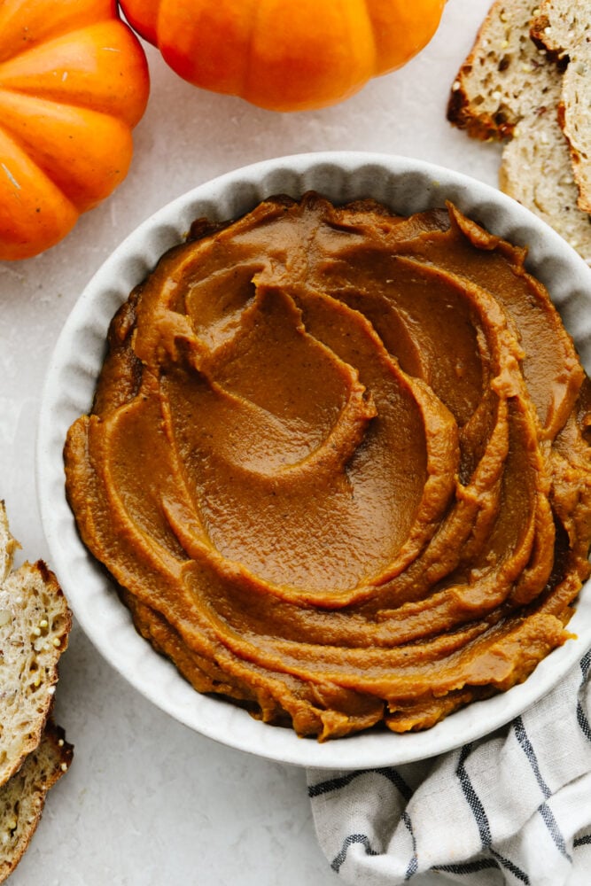 Pumpkin butter is thick, creamy, and delicious! It's super sweet with the perfect amount of pumpkin flavoring and can be put on basically anything! It's so delicious, your family will go crazy over it! Pumpkin butter in a bowl.