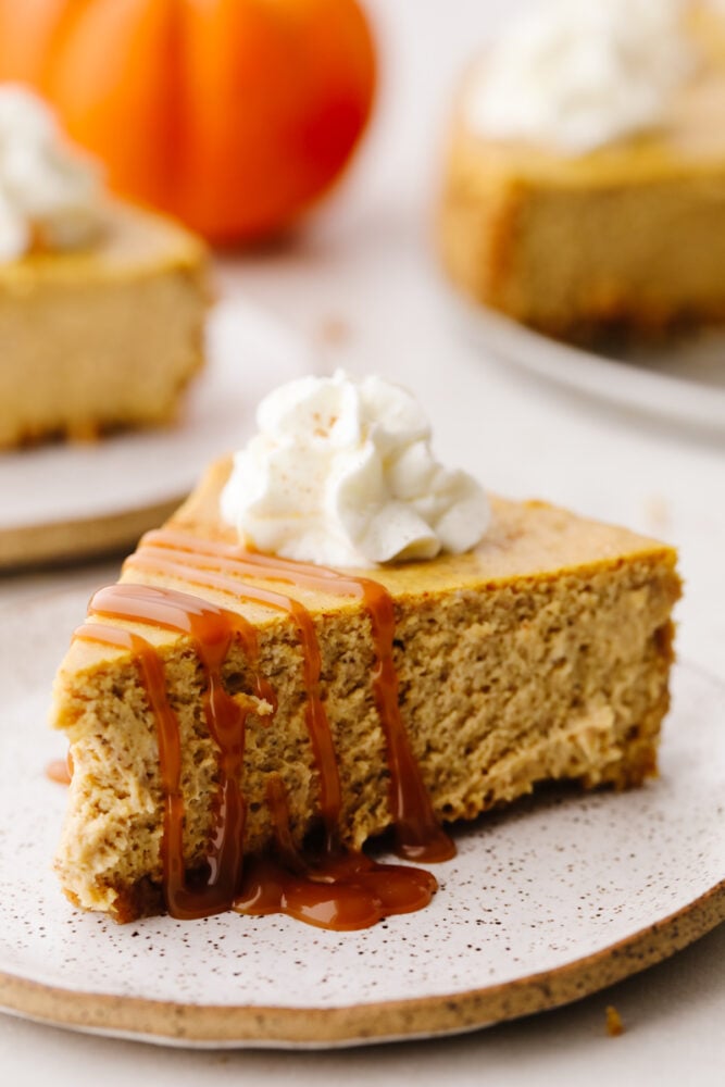 This pumpkin cheesecake that is drizzled with caramel sauce is the ultimate fall dessert. It's rich, creamy, and spiced to perfection! A slice of pumpkin cheesecake drizzled with a homemade caramel sauce.