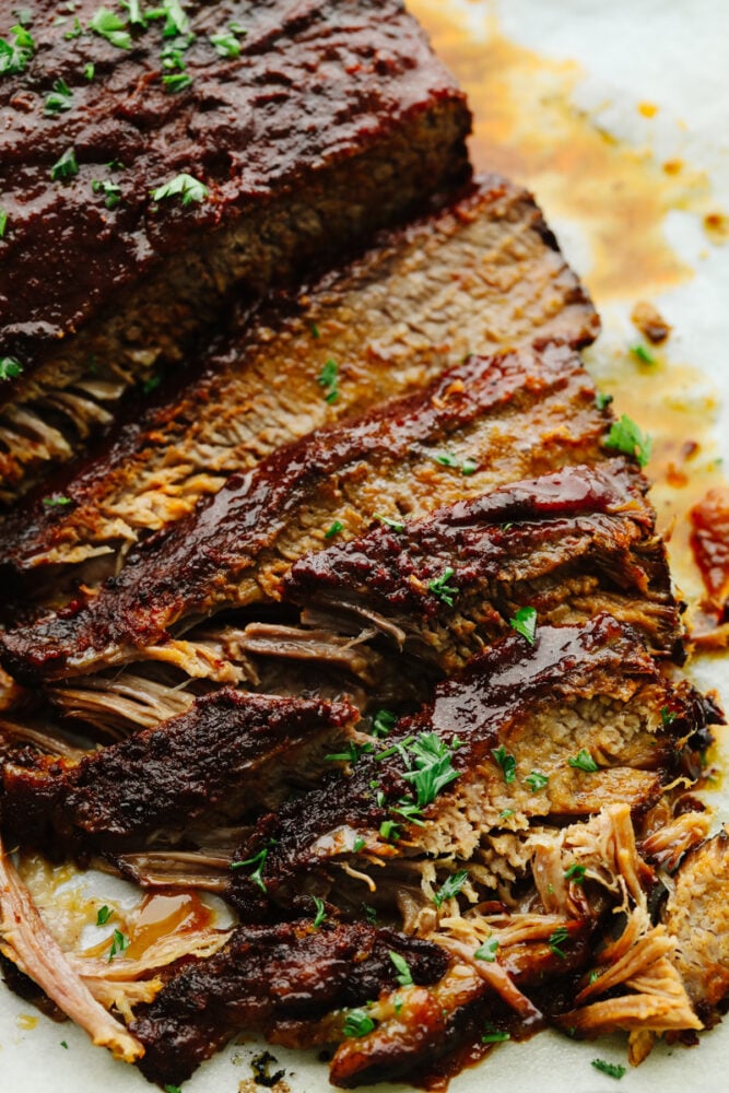 This Slow Cooker Beef Brisket is melt-in-your-mouth tender, packed with flavor, and practically cooks itself. Perfect for easy family dinners or feeding a hungry crowd! A zoomed in picture of a sliced slow cooker beef brisket.