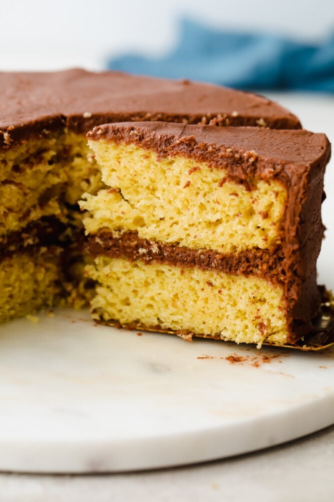 Yellow cake mix is a staple recipe that can be used in countless desserts! It's super easy to throw together and only requires a handful of ingredients. Yellow cake with chocolate frosting sliced from the cake.
