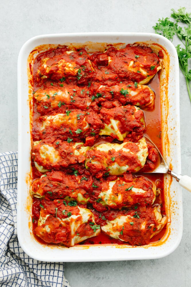 These stuffed cabbage rolls are SOO GOOD! These are packed with lean ground beef, onion, garlic, dill, and just a hint of nutmeg. The cabbage rolls are slow-cooked in marinara sauce until they're melt-in-your-mouth delicious! A casserole dish filled with cooked cabbage rolls.