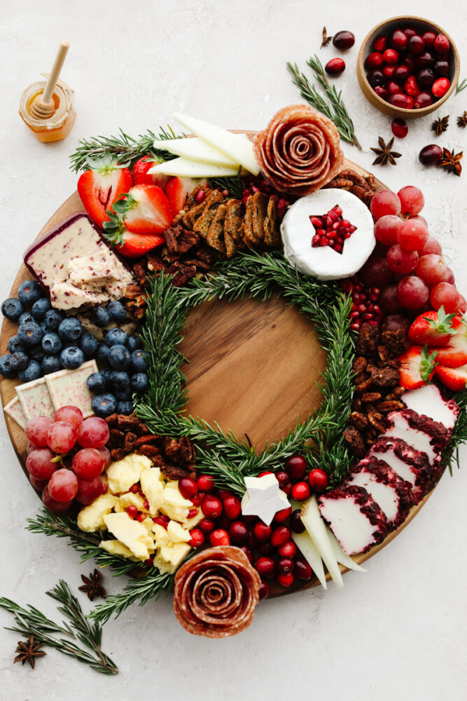 This Christmas wreath charcuterie board is the perfect festive touch to any holiday party! It's stunning and delicious! Plus, it's super easy to make and all of your guests will be so impressed! A Christmas wreath charcuterie board.