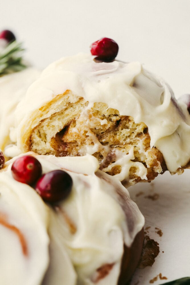 The holiday season doesn't get much more festive at the dinner table than with this cinnamon roll wreath! It's beautiful and delicious which makes it the perfect choice for your holiday breakfast, brunch, or dessert! A cinnamon roll wreath being sliced.