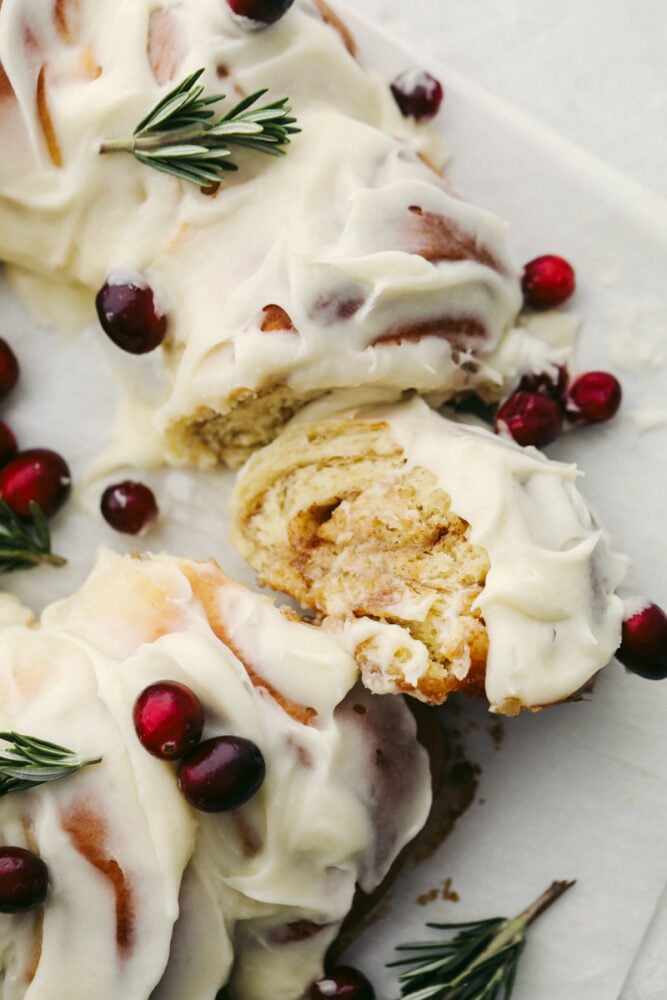 The holiday season doesn't get much more festive at the dinner table than with this cinnamon roll wreath! It's beautiful and delicious which makes it the perfect choice for your holiday breakfast, brunch, or dessert! The top view of a cinnamon roll wreath that is sliced.