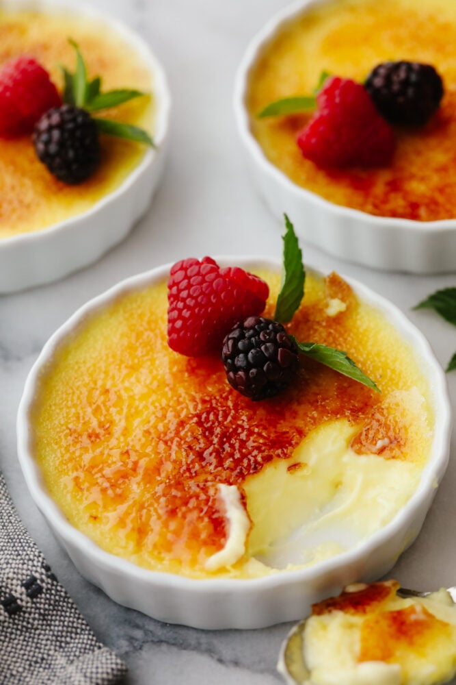 This creme brรปlรฉeย is a simple but elegant dessert that will impress all of your guests! You just can't beat a creamy custard topped with caramelized sugar and delicious fresh fruit! Creme brรปlรฉe topped with fruit.