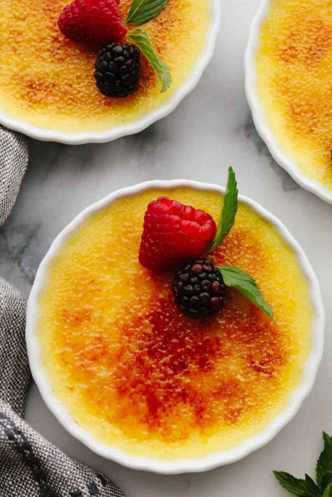 This creme brรปlรฉeย is a simple but elegant dessert that will impress all of your guests! You just can't beat a creamy custard topped with caramelized sugar and delicious fresh fruit! Creme brรปlรฉe in a ramekin, ready to eat!