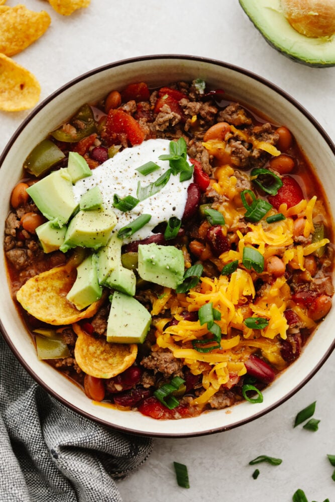 Crockpot chili is the ultimate comfort food! This chili is SO easy and insanely good that everyone will come back for seconds! A bowl of chili with toppings.