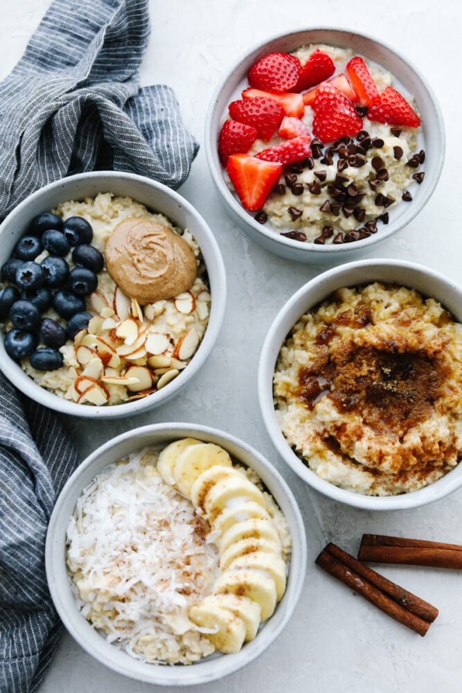 A warm, tasty bowl of homemade oatmeal is the perfect way to start your day! Here are 4 yummy variations filled with fresh fruit, nuts, brown sugar, and more! 4 bowls of homemade oatmeal with various toppings.