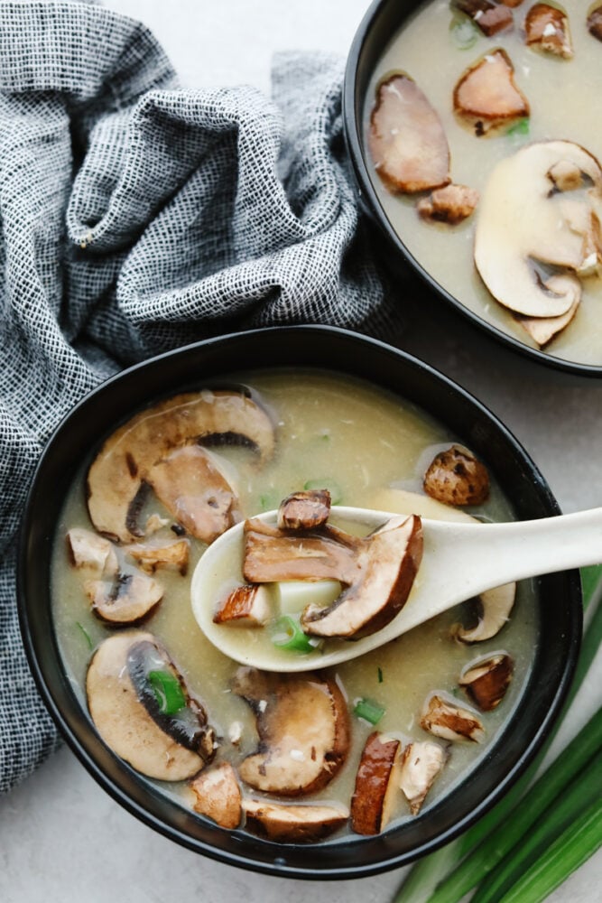 Hot and sour soup is savory, delicious and makes my mouth water just thinking about it! You can't beat a soup that's filled with mushrooms, bamboo shoots, tofu and veggies. It tastes better than at a restaurant! A bowl of hot and sour soup with a serving spoon, ready to eat!