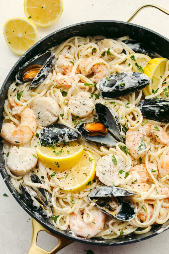 My seafood pasta has a silky lemon garlic cream sauce that is to die for! It's loaded with tender shrimp, scallops, and mussels. Itโs the perfect date night dish! Lemon garlic seafood pasta all mixed and ready to eat!