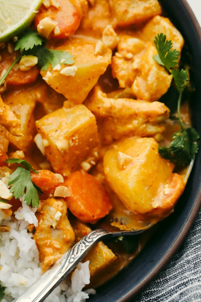 This massaman curry is insanely delicious!! Tender and juicy chicken mixed with a creamy blend of flavors gives it the best taste that ALL of your guests will love!! Massaman Curry in a bowl with white rice.