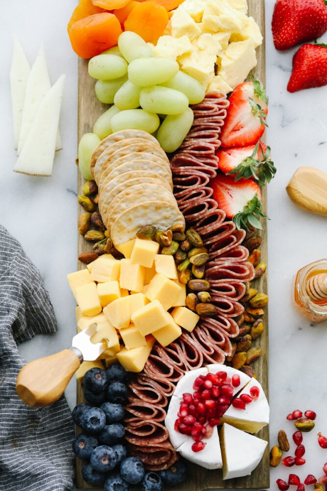 A simple charcuterie board is all that you need for any holiday or event! Filled with all of your favorite things, it will for sure be the star of the show! A simple charcuterie board filled with fruits, crackers, nuts and meats.