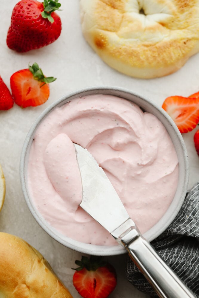 This strawberry cream cheese is rich, creamy, and full of delicious flavor! It's simple to make and will have all of your breakfast bagels tasting SOO GOOD! Strawberry cream cheese in a bowl with a butter knife.