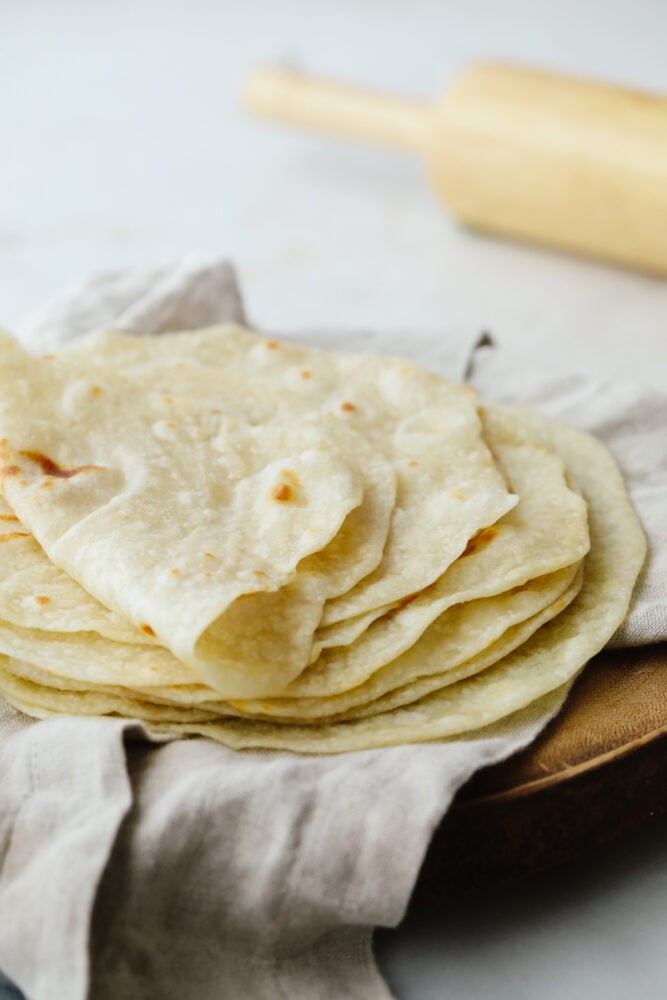 These homemade tortillas not only taste amazing but they are simple and easy to make. They will knock your socks off and take any recipe to the next level! A stack of tortillas.