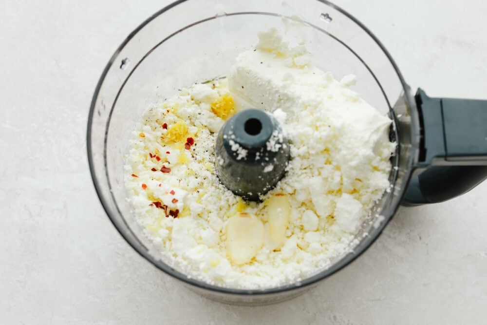 It doesn't get much better than whipped feta dip!! Perfectly creamy and garnished with herbs and spices, this dip will be the talk of the party! Ingredients in a food processor.