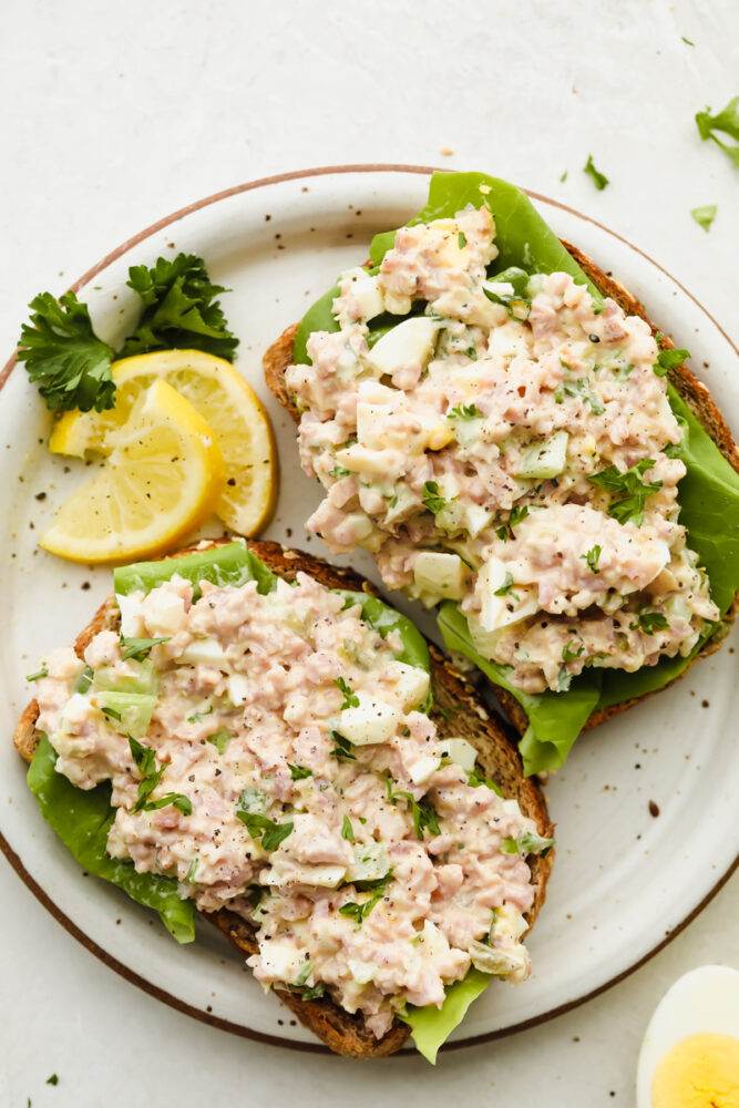 This amazing ham salad is filled with so much flavor! Super simple and easy to make, use some leftover ham and you can whip this up for lunch in under 10 minutes!ย Ham salad on bread with some lettuce.