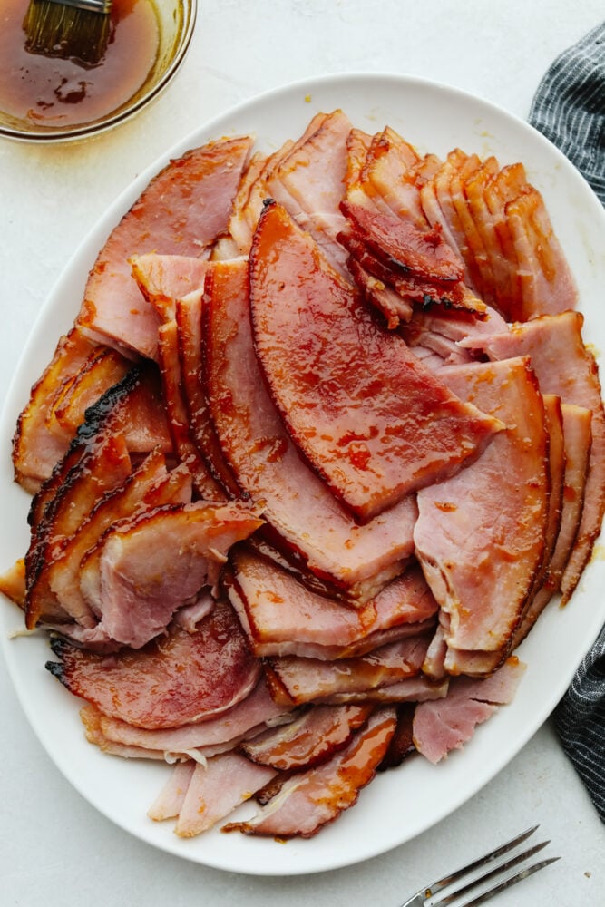 If you are looking for the perfect ham to be the star of your Christmas dinner, this apricot glazed ham is it! It has a delicious apricot glaze drizzled on top and it's baked to perfection. A platter of sliced apricot glazed ham.