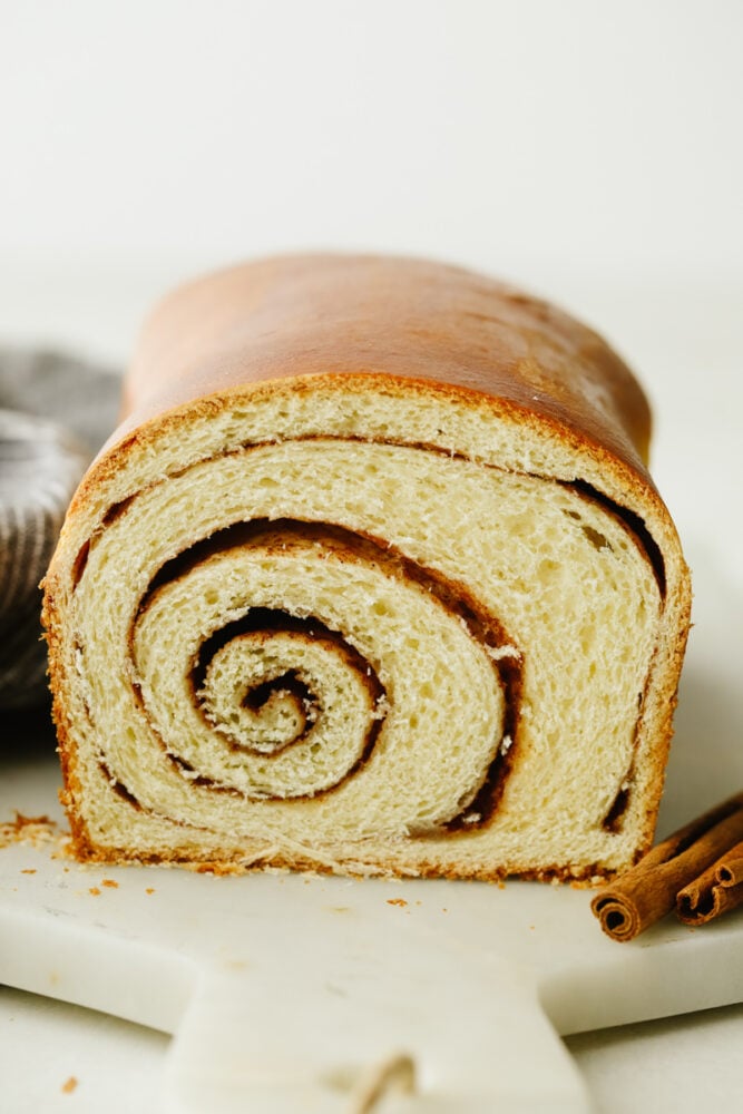This bread not only tastes amazing but those thick cinnamon swirls make it gorgeous enough to impress any guest! WIth the perfectly golden outside and delicious cinnamon flavor on the inside, you will come back to this again and again! A loaf of cinnamon swirl bread with the inside swirl showing.