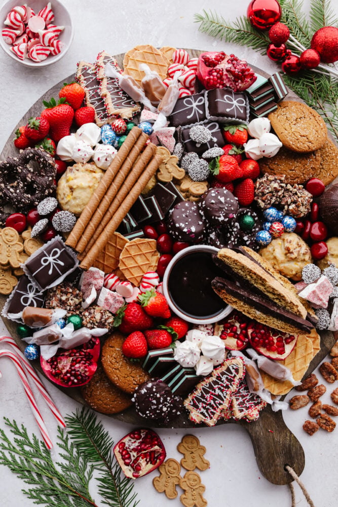 If you are looking for a Christmas dessert to impress your guests then this charcuterie board is it! Stunning and delicious, this board is full of candy, chocolate, cookies, and fruit for the holiday season!ย A Christmas dessert charcuterie board.
