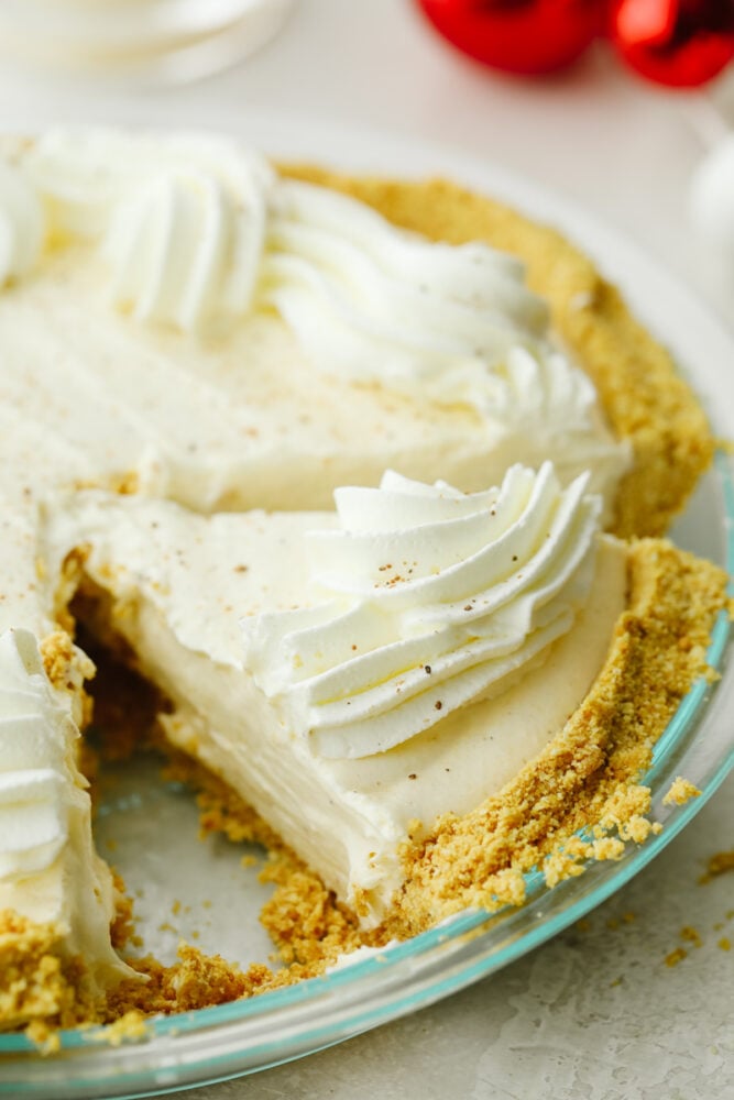 No-bake eggnog pie really takes the festivities of the season up a notch! Creamy, delicious, and made with the perfect eggnog flavor, this pie will be a hit at all of your parties! Eggnog pie cut in the pie pan.
