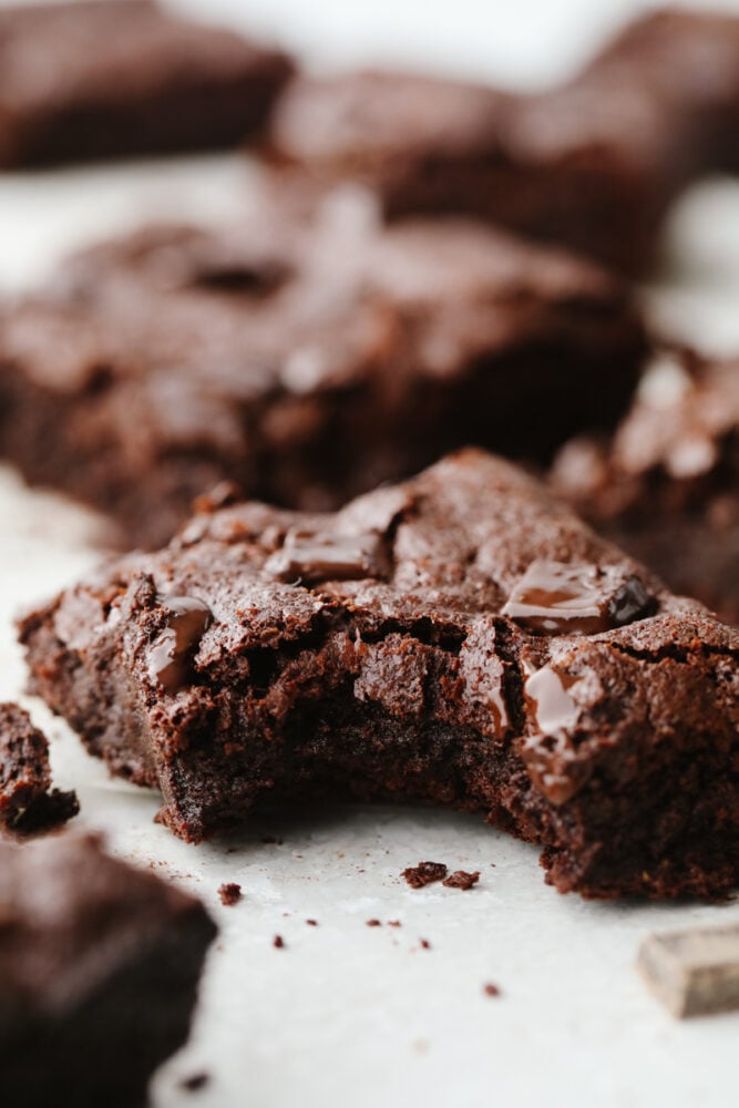 These flourless chocolate brownies are absolute heaven! The thin, chewy texture and sweet flavor are so delicious that I bet that you can't just stop at one! A flourless chocolate brownie with a bite taken out of it.