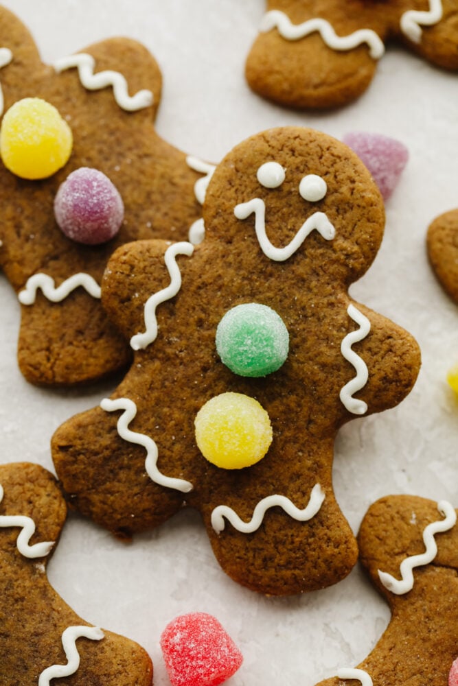 Soft and chewy gingerbread cookies are my favorite Christmas treat to decorate with my kids. They're just as delicious to eat as they are cute to look at! Zoomed in picture of a gingerbread cookies with gumdrops as buttons.