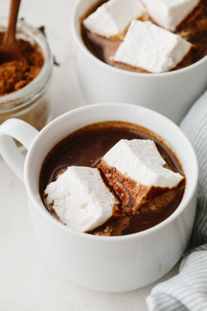 Once you make marshmallows from scratch, you'll never go back! These homemade marshmallows are ultra-soft and delicious, ready for hot chocolate and s'mores! 2 homemade marshmallows in a cup of hot chocolate.