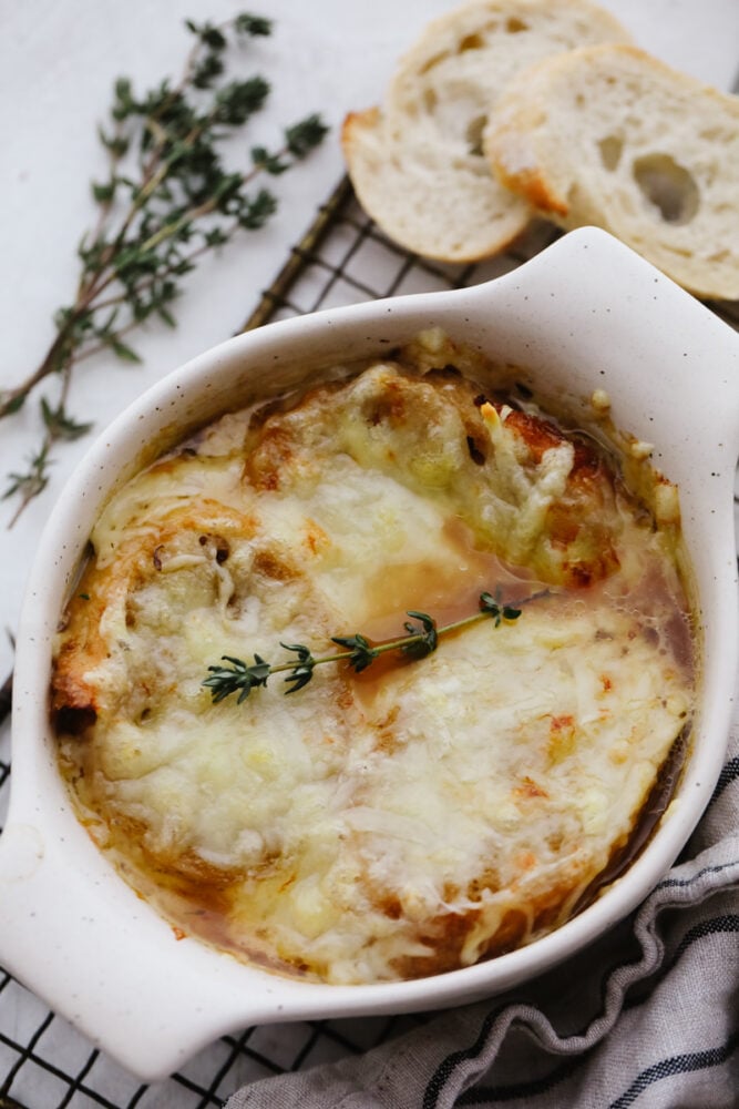 French onion soup is a classic that you can now easily cook in your instant pot! Flavored to perfection and topped with delicious cheese this soup will warm you up on any cold winter day. A bowl of French onion soup on a cooling rack.