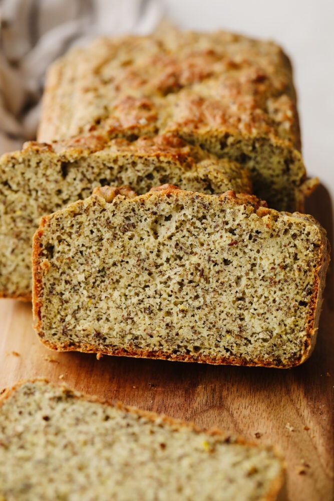 This keto bread is simple and full of delicious flavor! The ingredients are super healthy but that doesn't take away from its amazingly moist texture and taste! Slices of keto bread on a wooden cutting board.
