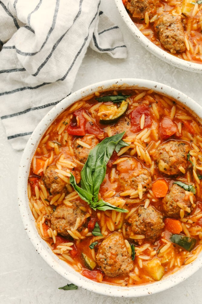 This meatball soup is hearty and full of amazing flavor. This only takes about 30 minutes to cook up and can be made with homemade or frozen meatballs! It's a MUST TRY recipe for sure! Meatball soup in a white bowl.