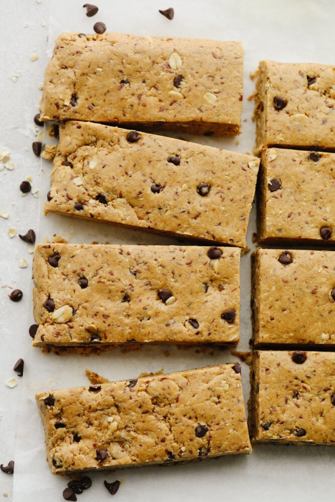 These healthy and easy to put together protein bars are the perfect snack to start the year off right! It's so simple and delicious, you will never buy them from the store again! A zoomed in shot of protein bars on parchment paper.