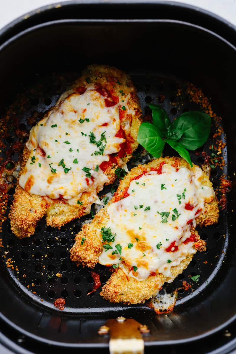 The air fryer is one of the most versatile appliances in today's kitchen! Learn how to use an air fryer to cook, reheat, and achieve that "fried" texture without frying in oil. Once you cook in the air fryer you will never look back! Fifth photo of chicken parmesan in the air fryer.