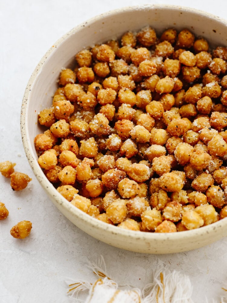 Air fryer chickpeas are crispy and flavored to perfection! With three different ways to season them, there will be a flavor for everyone. These crunchy, roasted chickpeas will become your new go-to snack! A bowl of roasted, seasoned chickpeas.